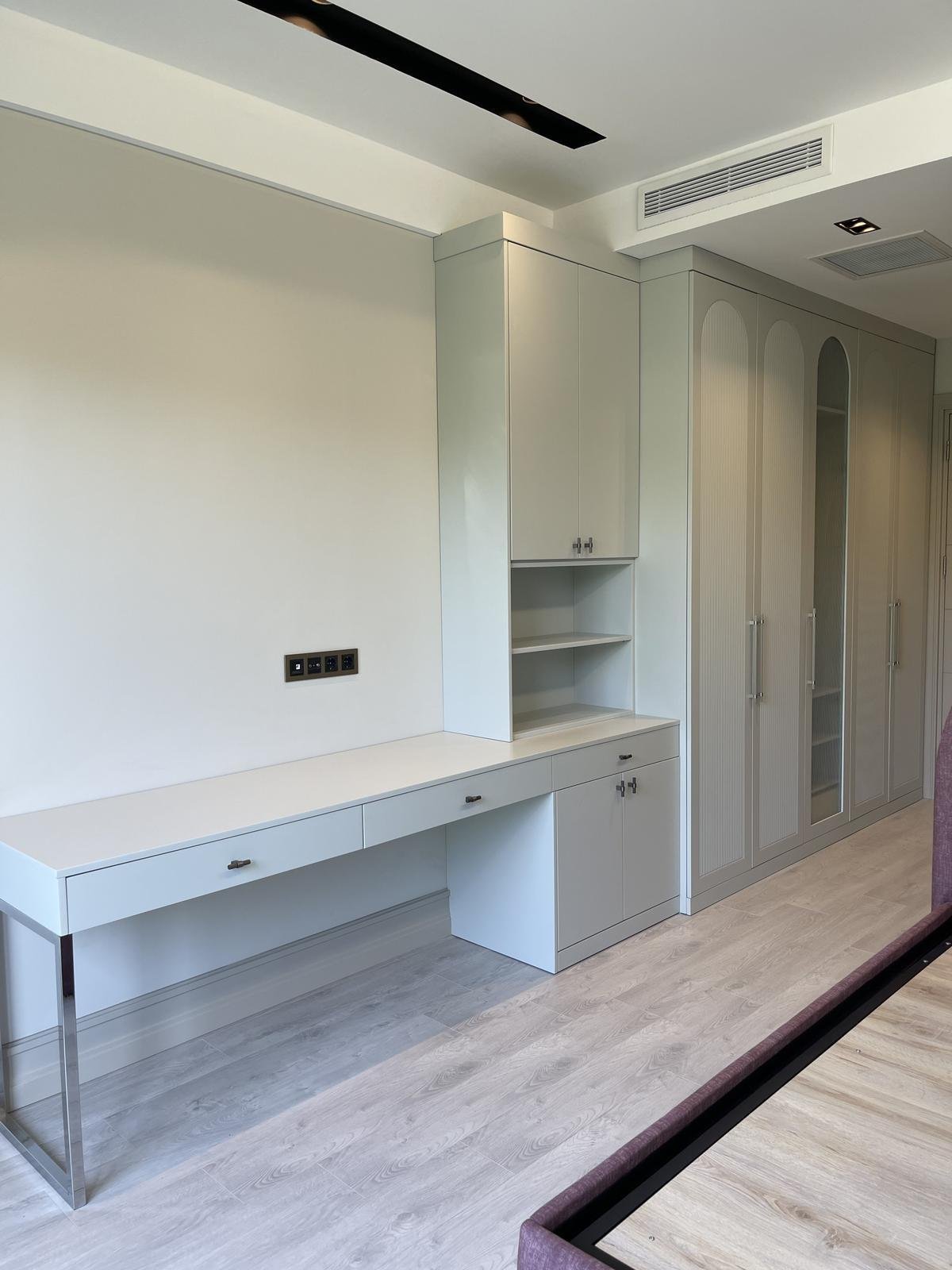 Built-in wardrobe and desk unit with arched glass doors